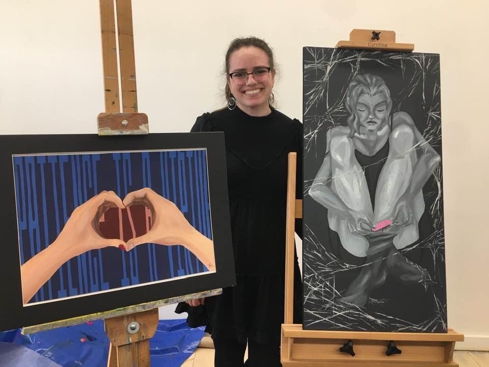 Ky standing with her art at a showing